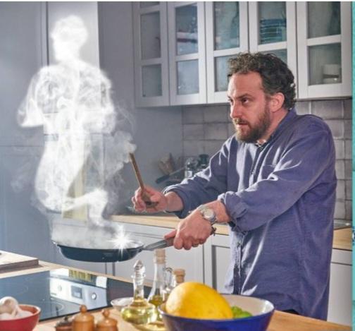 Un homme fait de la cuisine, et il y a un génie fait de fumée qui sort de la poêle